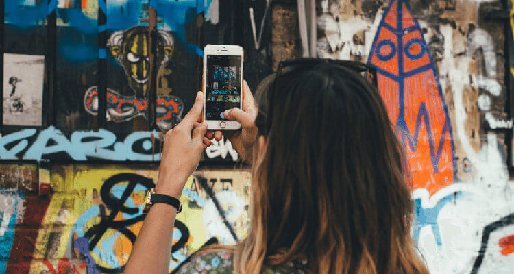 girl taking photo street art